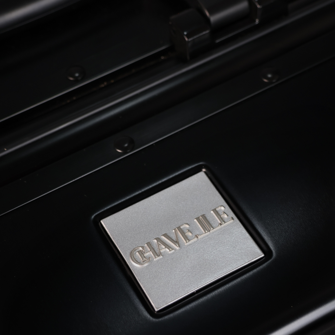 CHAVELLE luxury aluminium suitcase black close-up of top handle and metal logo