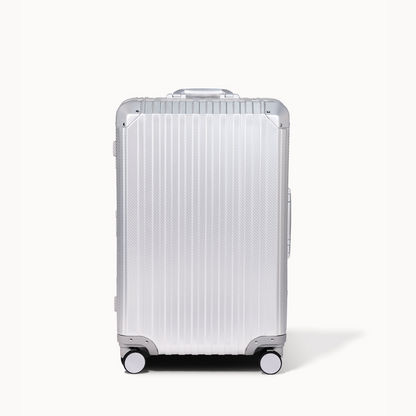 Silver suitcase with a ribbed texture on a white background