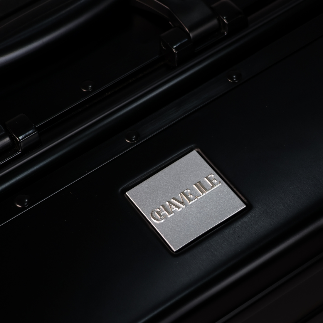 CHAVELLE luxury aluminium suitcase black close-up of top handle and metal logo