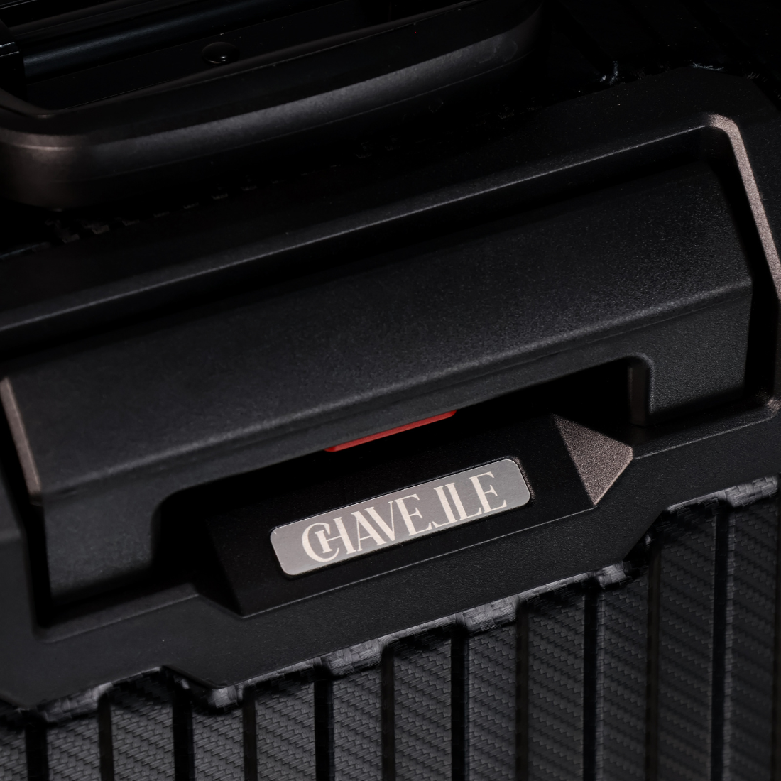 Close-up of a black grill with 'CHAVELLE' branding on a dark background