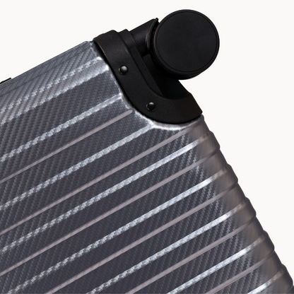 Close-up of a silver suitcase with black handle on a white background