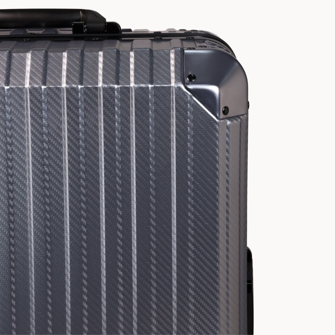 Close-up of a textured gray suitcase corner on a white background