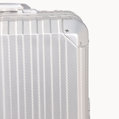 Close-up of a silver suitcase with a textured surface on a white background
