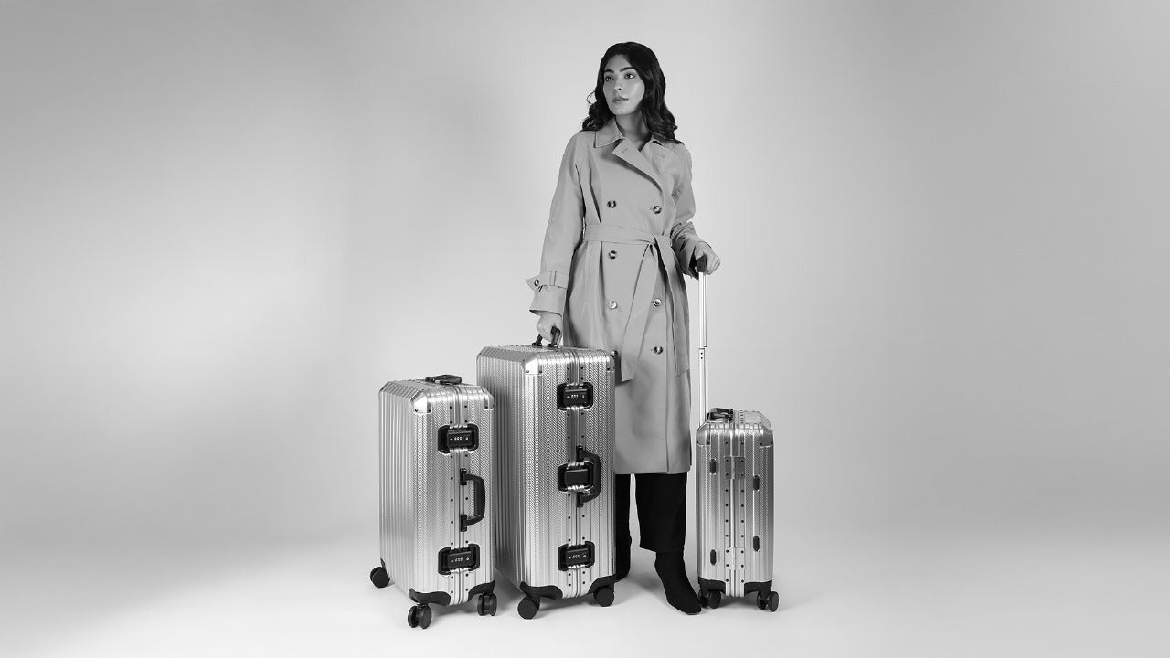 CHAVELLE Excellence Carbon Fibre Series set of 3 luxury premium suitcases carried by elegant model