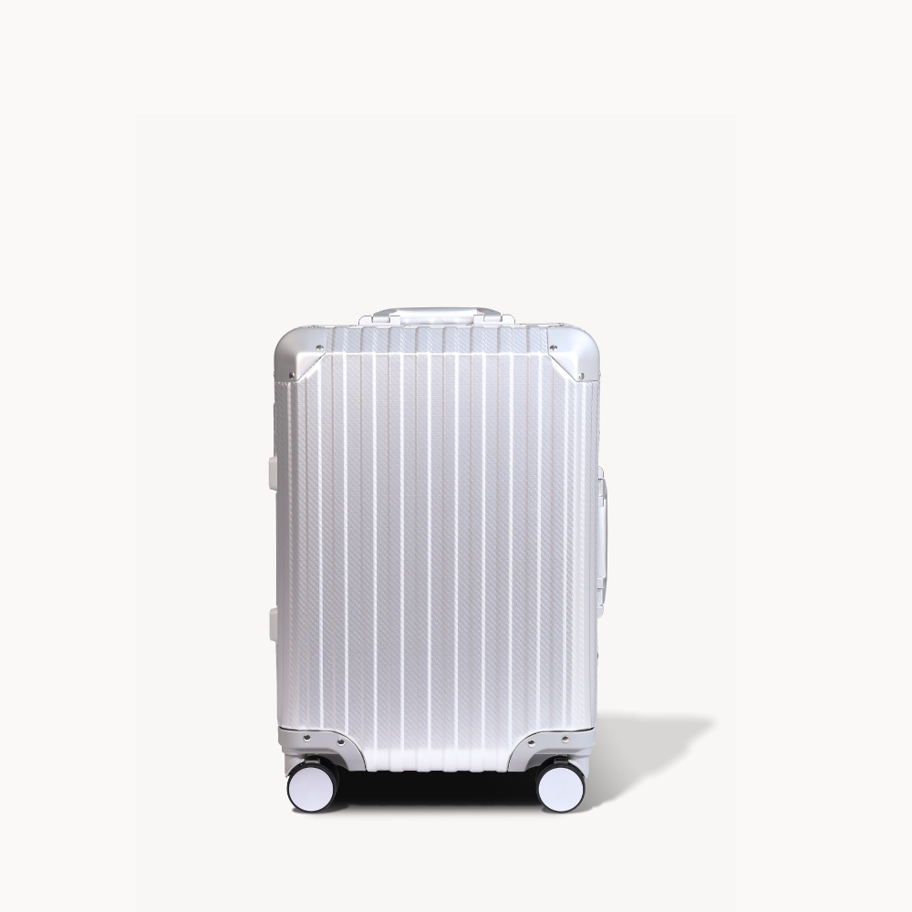 Silver suitcase with a ribbed texture on a white background