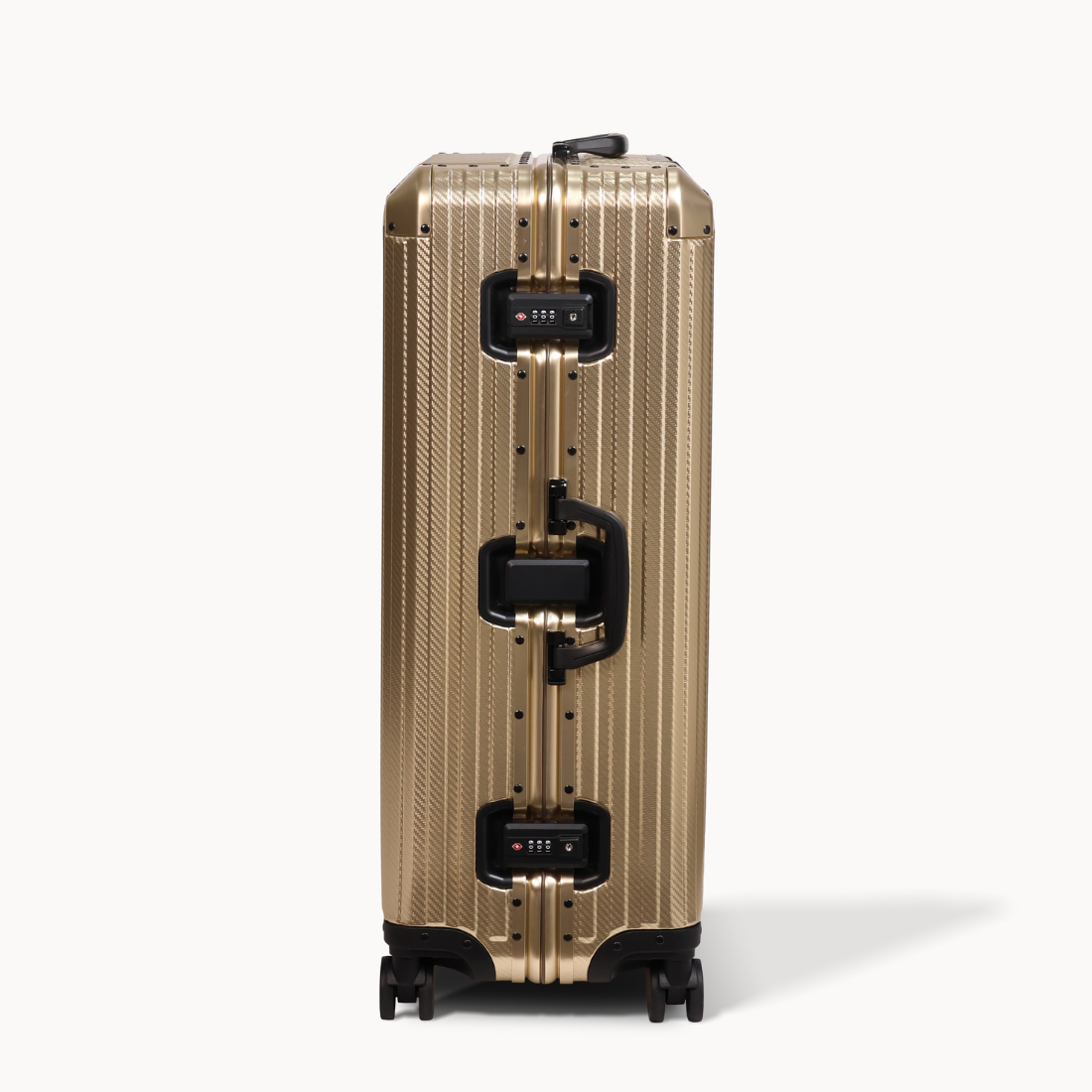 Gold suitcase with black handle and wheels on a white background