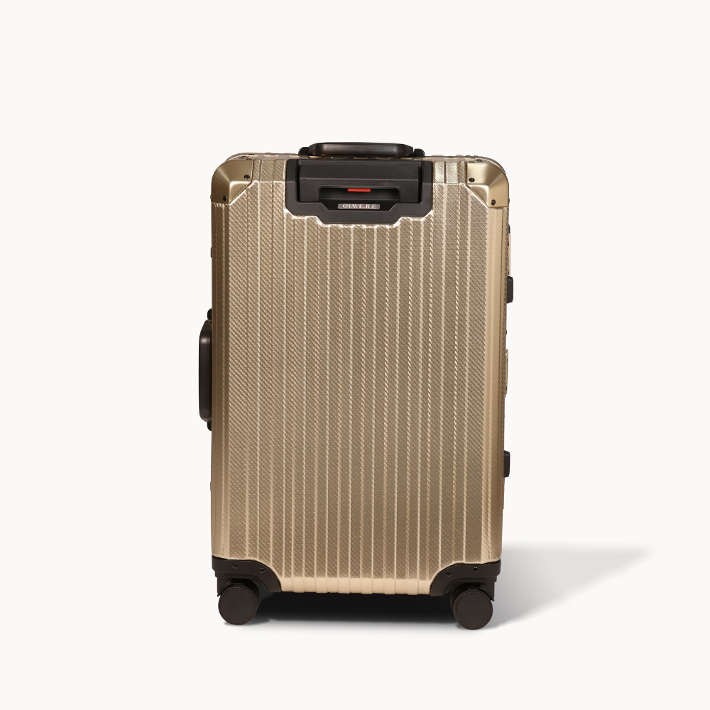 Gold suitcase with black wheels and handle on a white background