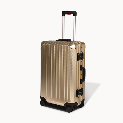 Gold suitcase with black wheels and handle on a white background