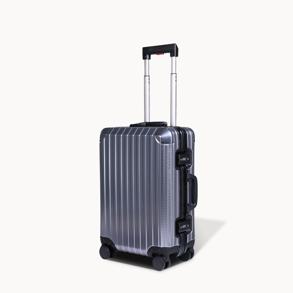 Silver suitcase with black handle and wheels on a white background