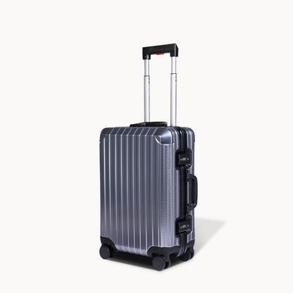 Silver suitcase with black handle and wheels on a white background